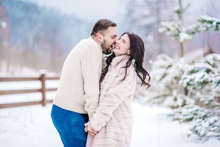a bride in a fur coat with a fiance among the Carpathian mountainsの写真素材