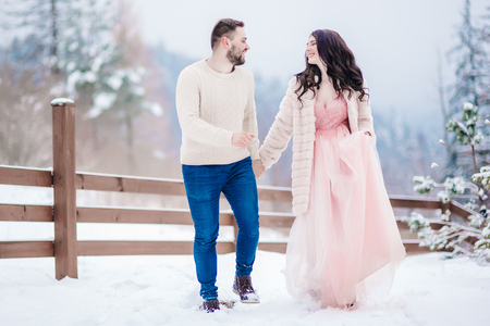 A bride in a fur coat with a groom among the Carpathian mountainsの写真素材