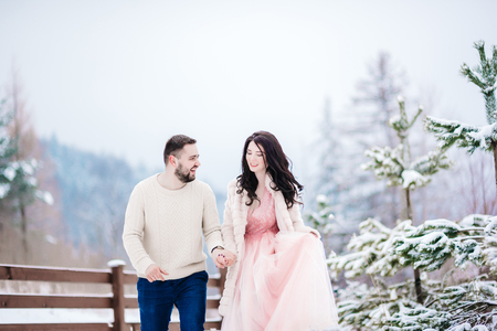 A bride in a fur coat with a groom among the Carpathian mountainsの写真素材