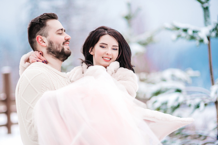 A bride in a fur coat with a groom among the Carpathian mountainsの写真素材