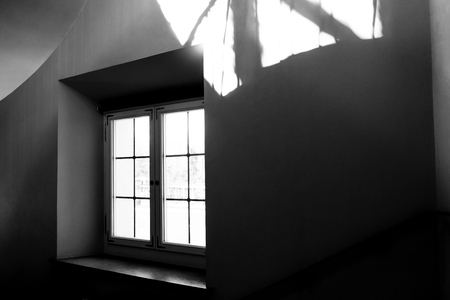 window of a mansion with a wide window sill on a spiral staircase leading to the courtyardの写真素材
