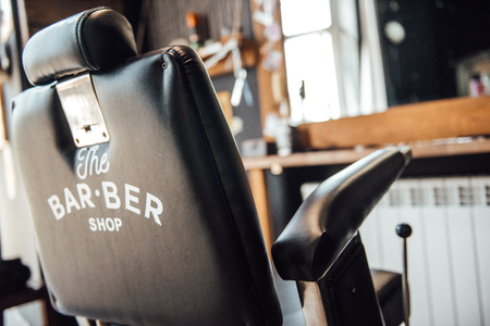 black barberman hairdressing chair on against the mirrorの写真素材