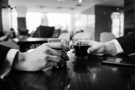 hands with glasses of drink at the bar