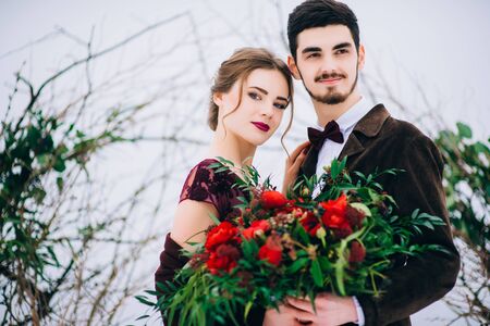 groom in a brown and bride in burgundy in the mountains Carpathiansの写真素材