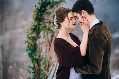 groom in a brown and bride in burgundy in the mountains Carpathiansの写真素材