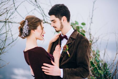 groom in a brown and bride in burgundy in the mountains Carpathiansの写真素材