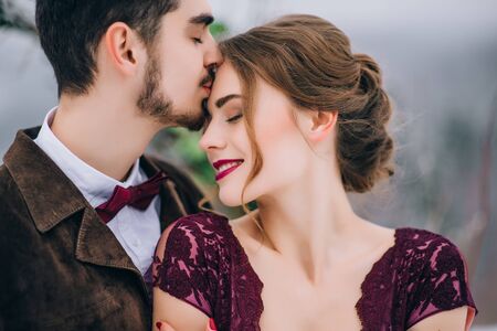 groom in a brown and bride in burgundy in the mountains Carpathiansの写真素材