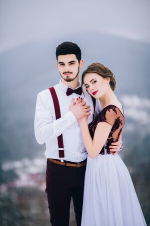 groom in a brown and bride in burgundy in the mountains Carpathiansの写真素材