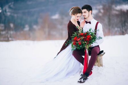 groom in a brown and bride in burgundy in the mountains Carpathiansの写真素材