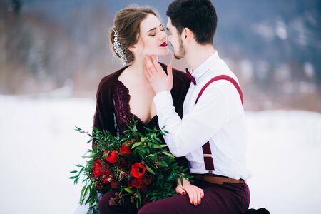 groom in a brown and bride in burgundy in the mountains Carpathiansの写真素材