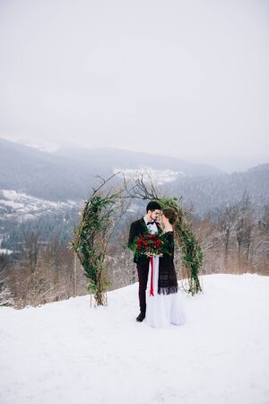 groom in a brown and bride in burgundy in the mountains Carpathiansの写真素材