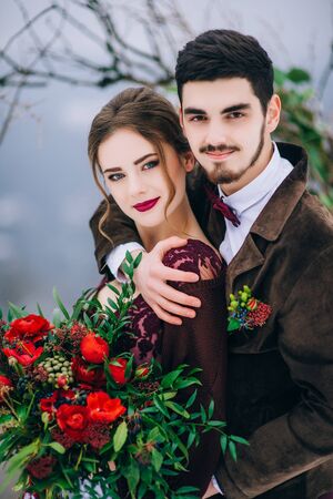 groom in a brown and bride in burgundy in the mountains Carpathiansの写真素材