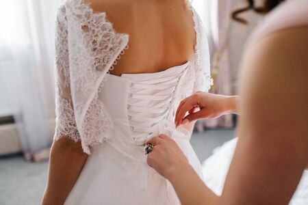 dress up the bride in a wedding dress with corset and lacingの写真素材
