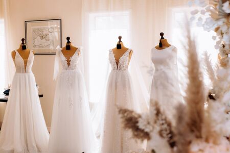 beautiful white wedding dresses hang on mannequinsの写真素材