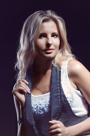 young, girl, blonde, jeans, clothes on a dark backgroundの写真素材