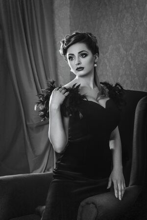 young brunette model girl and actress in a chair, black and whiteの写真素材