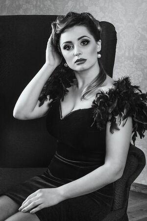 young brunette model girl and actress in a chair, black and whiteの写真素材