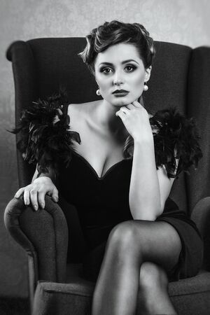 young brunette model girl and actress in a chair, black and whiteの写真素材