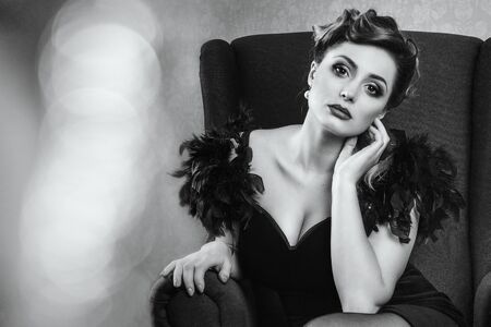 young brunette model girl and actress in a chair, black and whiteの写真素材