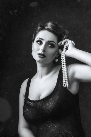 young brunette model girl and actress with pearl beads, black and whiteの写真素材