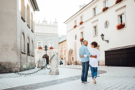 guy and a girl happily walk in the morning on the empty streets of old Europeの写真素材