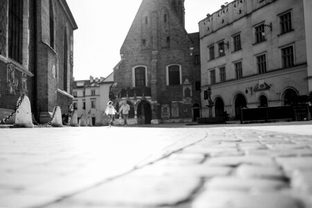 guy and a girl happily walk in the morning on the empty streets of old Europeの写真素材