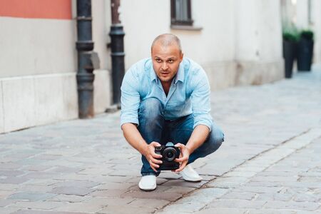 young guy, photographer walking in the old streets poland of europeの写真素材