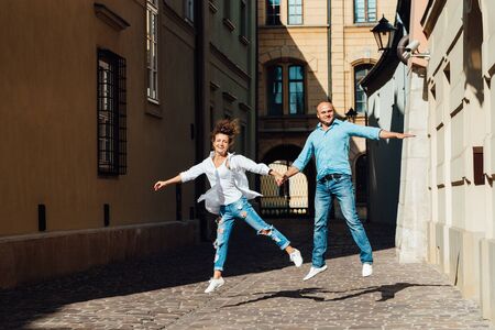 guy and a girl happily walk in the morning on the empty streets of old Europeの写真素材