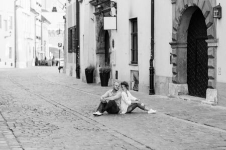 guy and a girl happily walk in the morning on the empty streets of old Europeの写真素材
