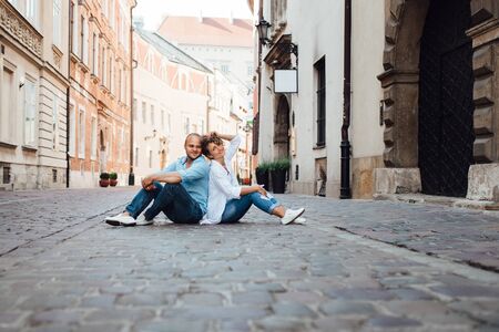 guy and a girl happily walk in the morning on the empty streets of old Europeの写真素材