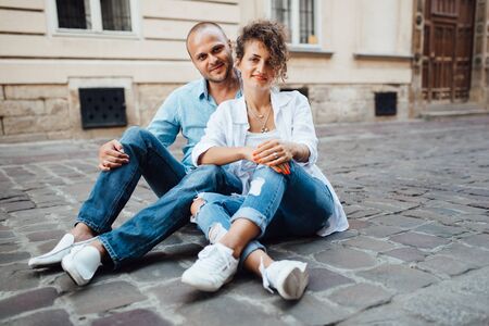 guy and a girl happily walk in the morning on the empty streets of old Europeの写真素材