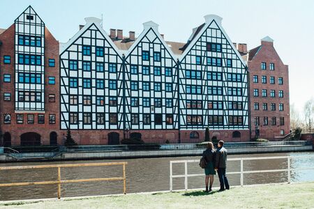 happy guy and girl walking along the tourist streets of old Europe in the city of Gdansk