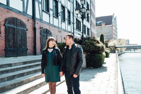 happy guy and girl walking along the tourist streets of old Europe in the city of Gdanskの写真素材