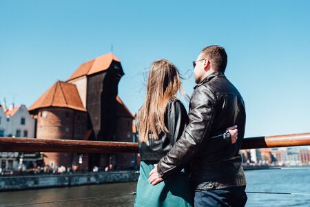 happy guy and girl walking along the tourist streets of old Europe in the city of Gdanskの写真素材