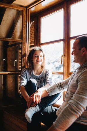 guy and girl in the house near the window overlooking a snowy landscapeの写真素材