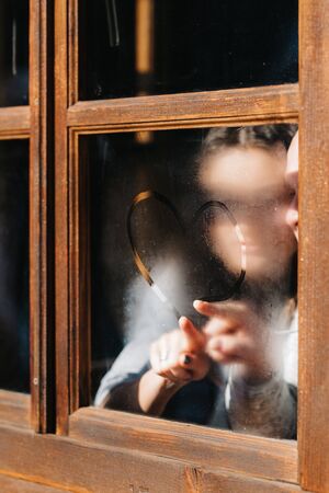 guy and girl in the house near the window overlooking a snowy landscapeの写真素材