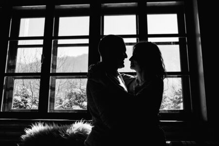 guy and girl in the house near the window overlooking a snowy landscapeの写真素材