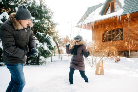 boy and girl outdoors on a winter walk playing snowballs and sleddingの写真素材