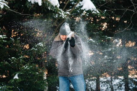 boy and girl outdoors on a winter walk playing snowballs and sleddingの写真素材