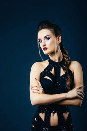 white girl modell on a dark background in a dress made of cut stripes of black fabricの写真素材