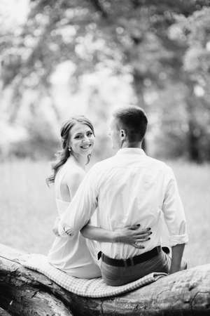 happy guy in a white shirt and a girl in a turquoise dress, the bride and groom are walking in the forest parkの写真素材