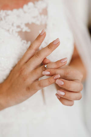 the bride gently touches her dear engagement ring