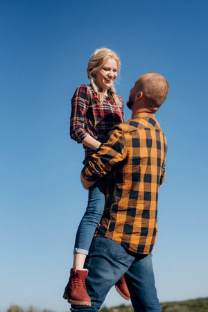Guy and girl in caged shirts and trekking shoes on garnit rocksの写真素材