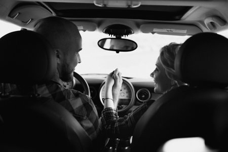 traveling by car of a young couple of a guy and a girl in plaid shirtsの写真素材