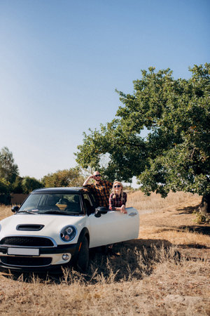 traveling by car of a young couple of a guy and a girl in plaid shirtsの写真素材