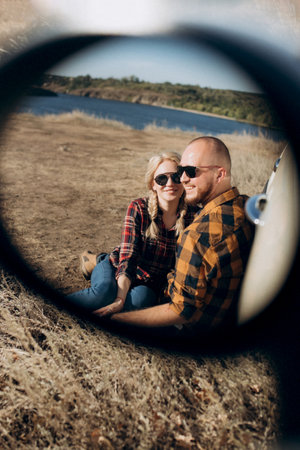 traveling by car of a young couple of a guy and a girl in plaid shirtsの写真素材