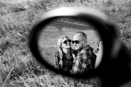 traveling by car of a young couple of a guy and a girl in plaid shirtsの写真素材