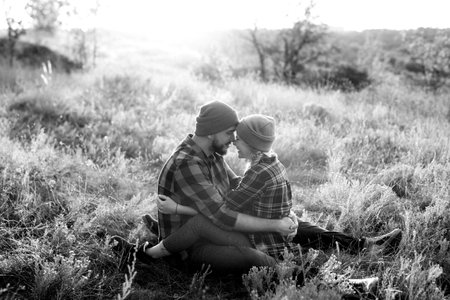 Cheerful guy and girl on a walk in bright knitted hats and plaid shirtsの写真素材