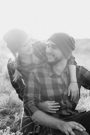Cheerful guy and girl on a walk in bright knitted hats and plaid shirtsの写真素材