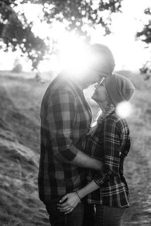Cheerful guy with a board and a blonde girl for a walk in plaid shirts at sunsetの写真素材